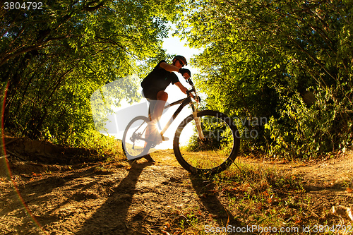 Image of Man Cyclist with bike on sunset