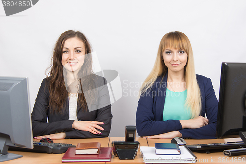 Image of Two young girls sitting at a colleague office table is divided into two jobs