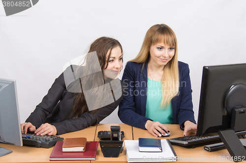 Image of She looked at his colleague computer screen at work in the office