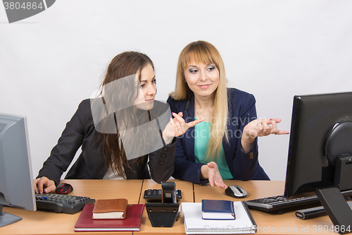 Image of Two colleagues in the office to discuss the electronic document in a computer screen