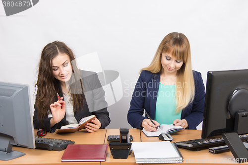 Image of  Two business women looking at diaries and make a plan of the day