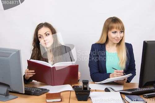 Image of Two business women working with one rival desktop