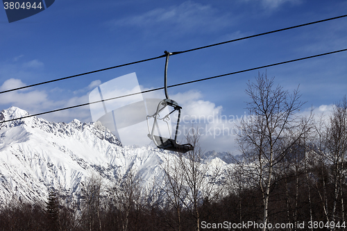 Image of Chair lift in snowy mountains at nice day