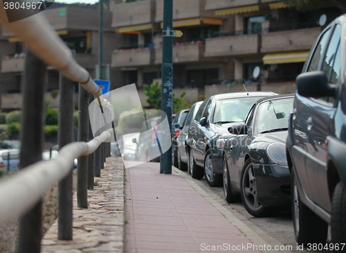 Image of sidewalk and line of cars leaving afar