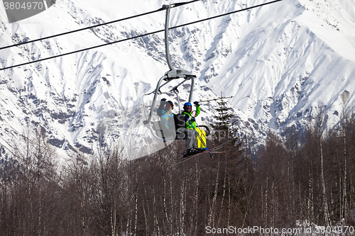 Image of Skiers family on chair-lift at nice sunny day