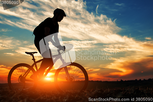 Image of Silhouette of a man on muontain-bike