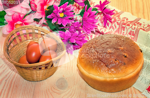 Image of Easter eggs, cake and artificial flowers.