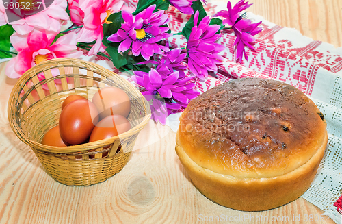 Image of Easter eggs, cake and artificial flowers.