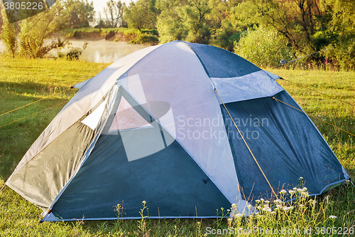 Image of Private camping tent on the meadow near the river.