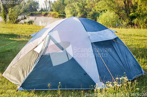 Image of Private camping tent on the meadow near the river.