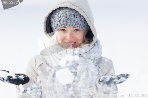 Image of Girl  playing with snow in winter.