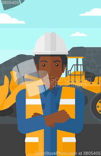 Image of Miner with mining equipment on background.