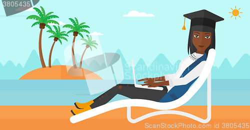 Image of Graduate lying on chaise lounge with laptop.