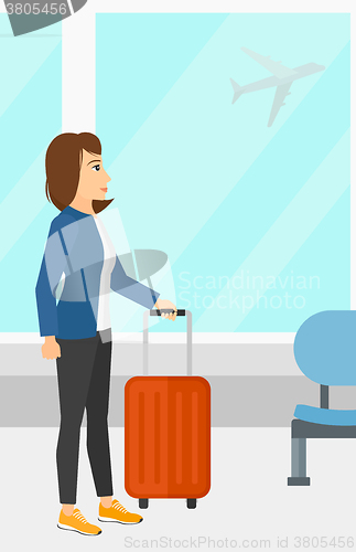 Image of Woman at airport with suitcase.