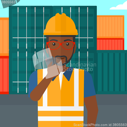 Image of Stevedore standing on cargo containers background.