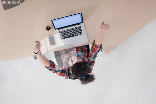 Image of top view of young business woman working on laptop