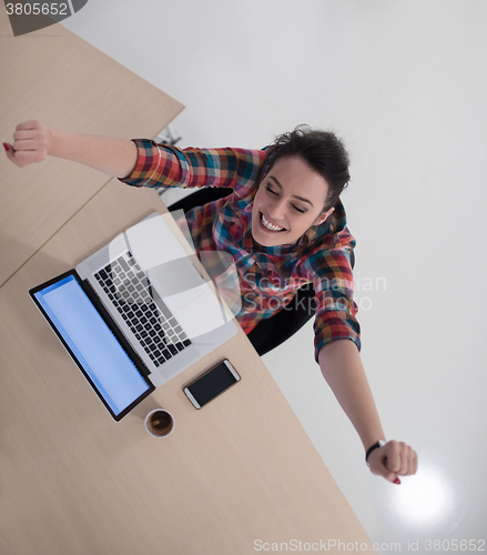 Image of top view of young business woman working on laptop