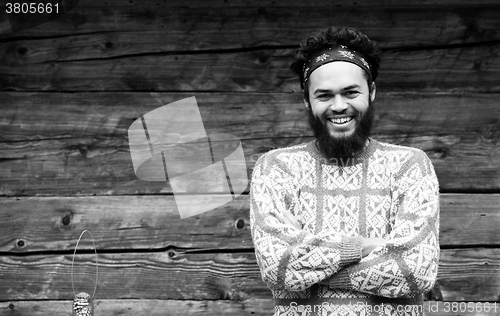 Image of portrait of young hipster in front of wooden house