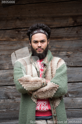 Image of portrait of young hipster in front of wooden house