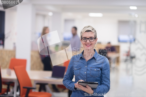 Image of portrait of young business woman at office with team in backgrou