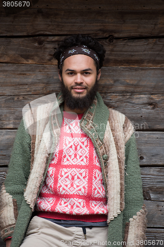 Image of portrait of young hipster in front of wooden house