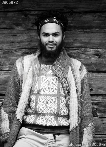 Image of portrait of young hipster in front of wooden house