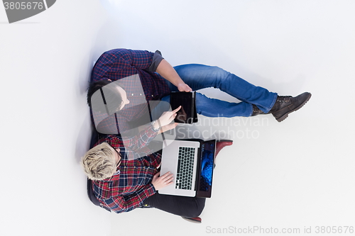 Image of top view of  couple working on laptop computer at startup office