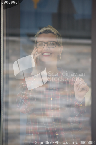 Image of business woman in meeting room  speaking by cell phone