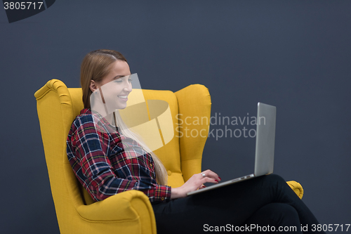 Image of startup business, woman  working on laptop and sitting on yellow