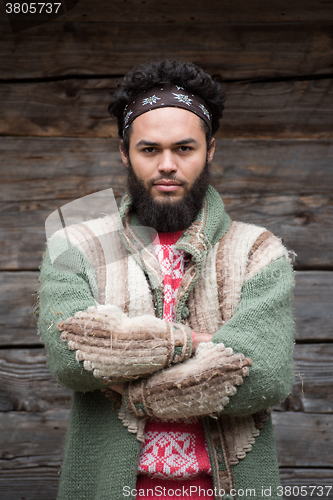 Image of portrait of young hipster in front of wooden house