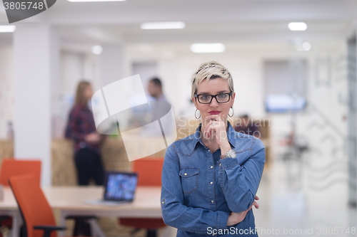 Image of portrait of young business woman at office with team in backgrou