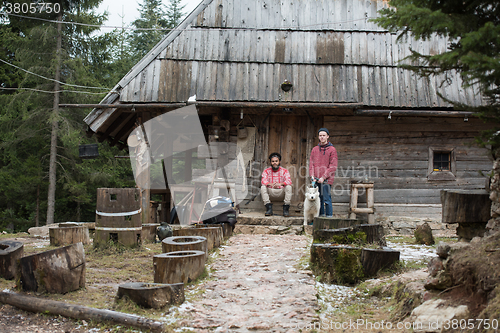 Image of frineds together in front of old wooden house