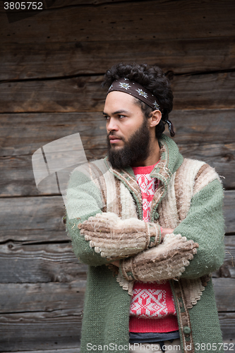 Image of portrait of young hipster in front of wooden house