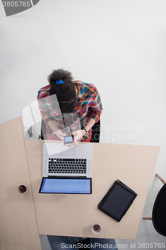 Image of top view of young business woman working on laptop