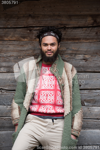 Image of portrait of young hipster in front of wooden house