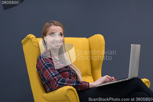 Image of startup business, woman  working on laptop and sitting on yellow