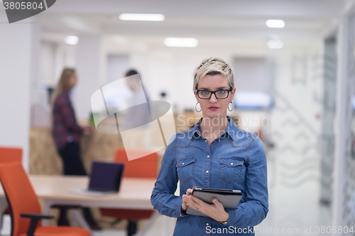 Image of portrait of young business woman at office with team in backgrou