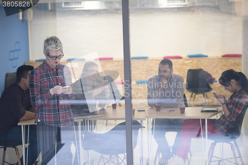 Image of business woman in meeting room  speaking by cell phone