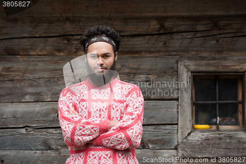 Image of portrait of young hipster in front of wooden house