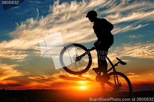 Image of Silhouette of a man on muontain-bike