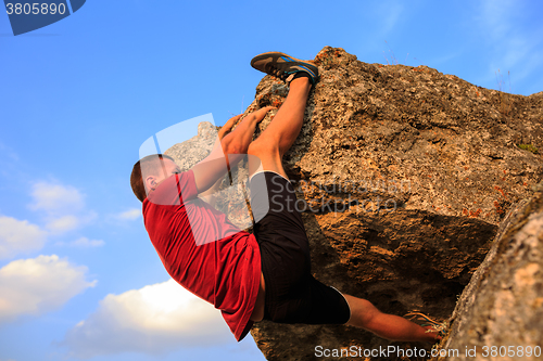 Image of Young man climbing on a wall