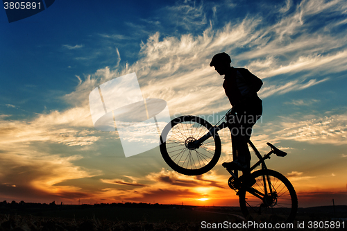 Image of Silhouette of a man on muontain-bike