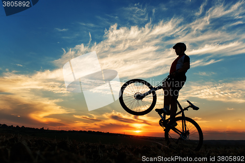 Image of Silhouette of a man on muontain-bike