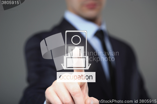Image of businessman pressing occupation button on virtual screens. 
