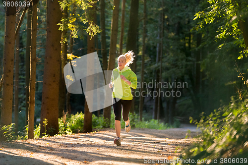Image of Pretty young girl runner in the forest. 