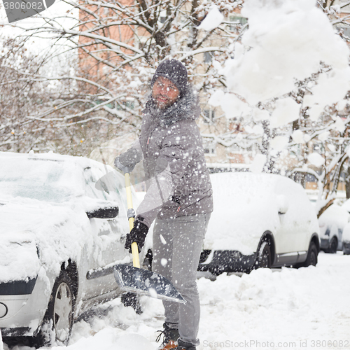 Image of Man shoveling snow in winter.