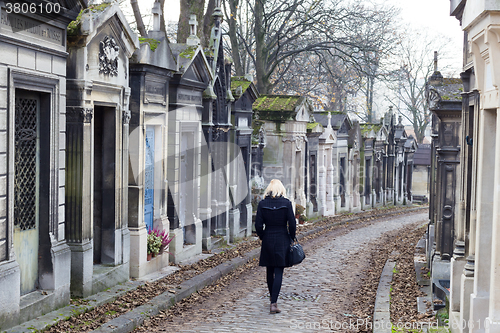 Image of Solitary woman visiting relatives grave.