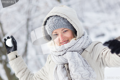 Image of Girl snowball fighting in winter time.