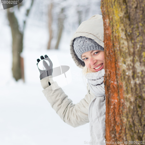 Image of Girl snowball fighting in winter time.