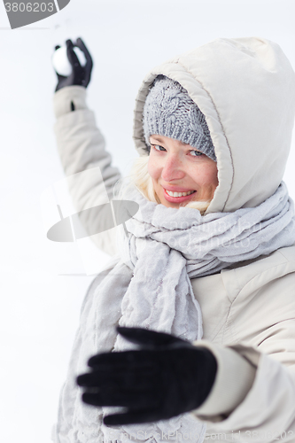 Image of Girl snowball fighting in winter time.